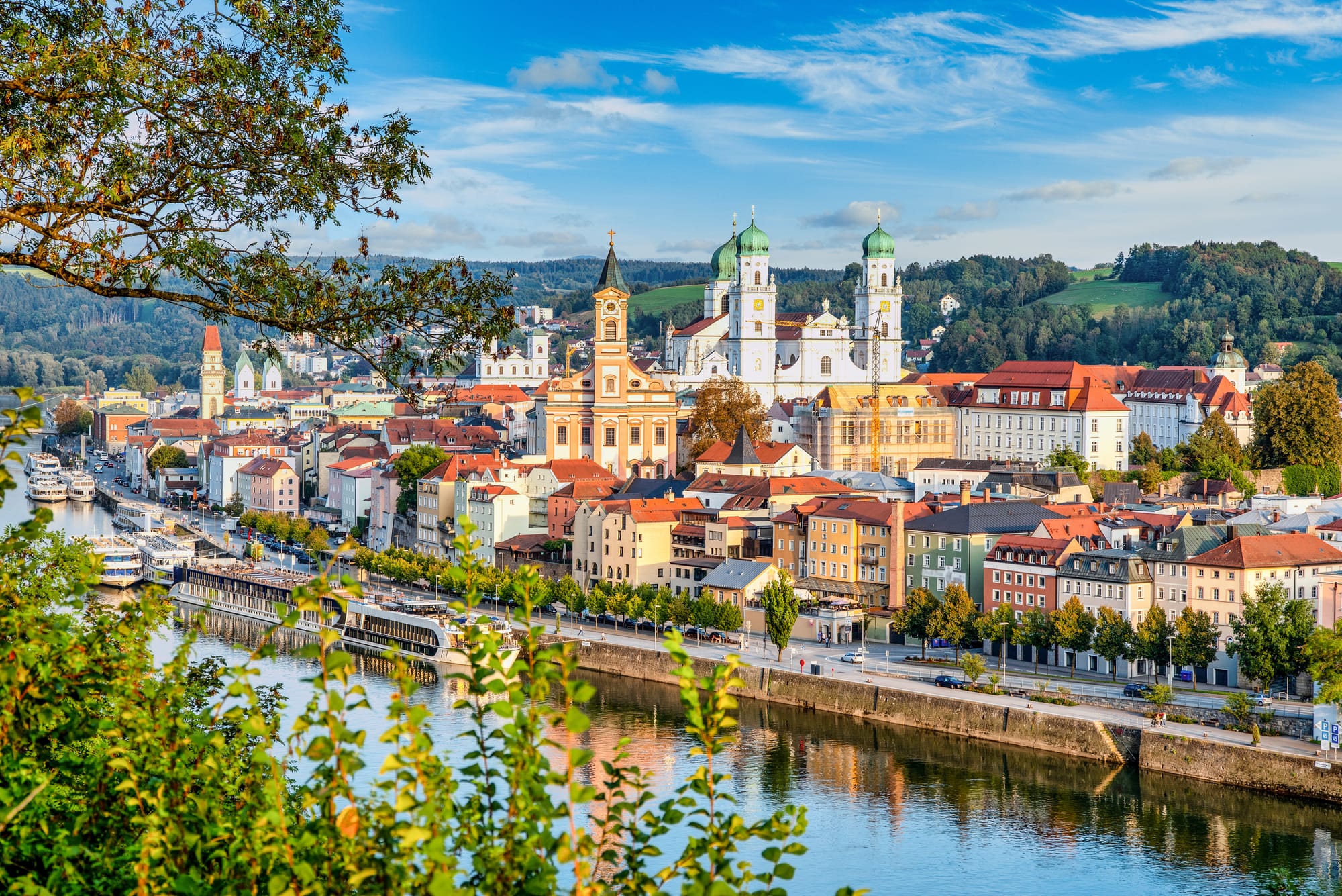 A view of Passau from across a river, with some trees in the foreground