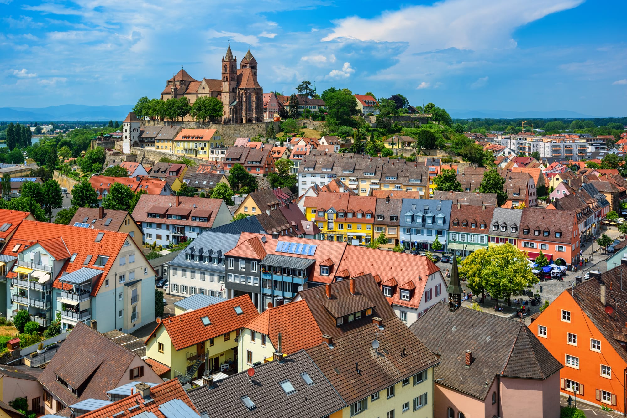 A look at Breisach old town from above, with a cathedral on a hill in the background