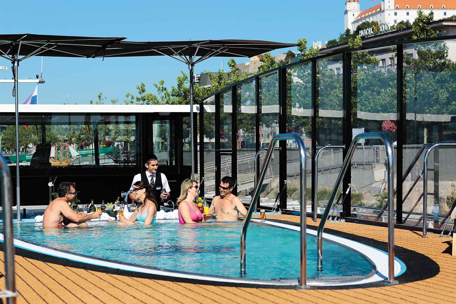 Young couples enjoying drinks in a small swimming pool on the deck of a cruise ship