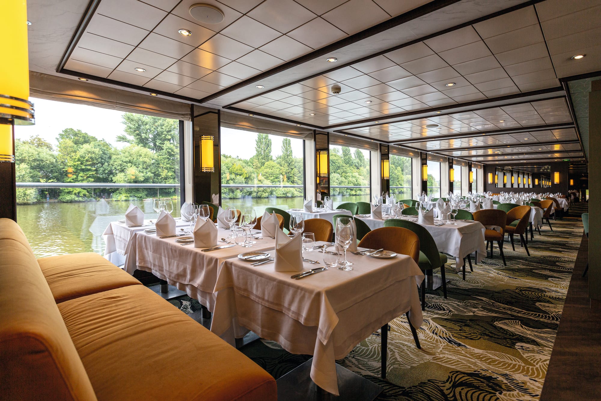 A restaurant on a river cruise ship with warm tones and a patterned carpet