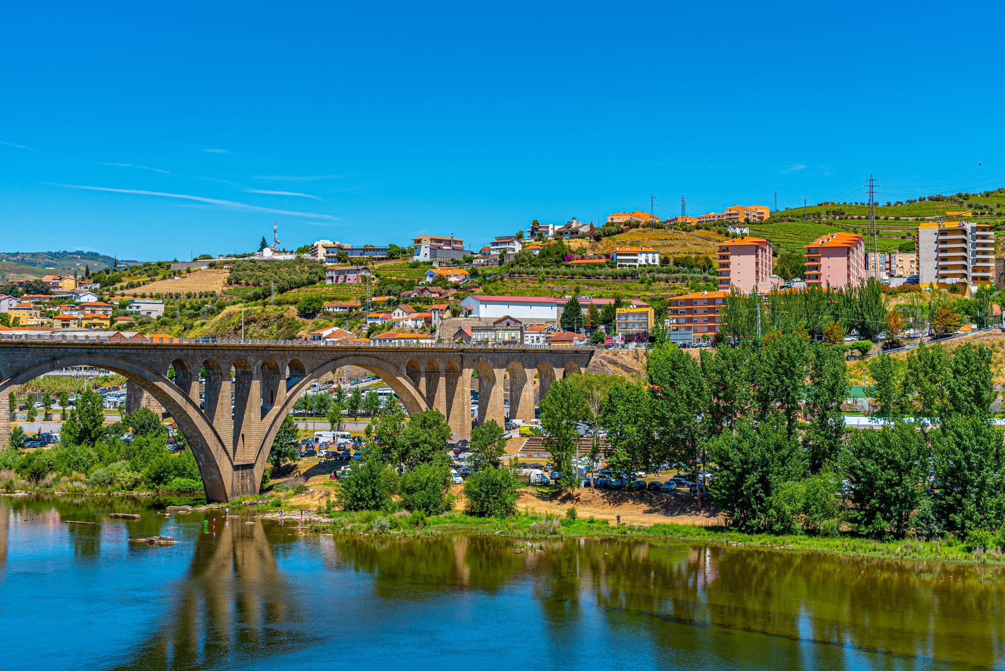 A small riverside town with terraced housing and a bridge in the foreground