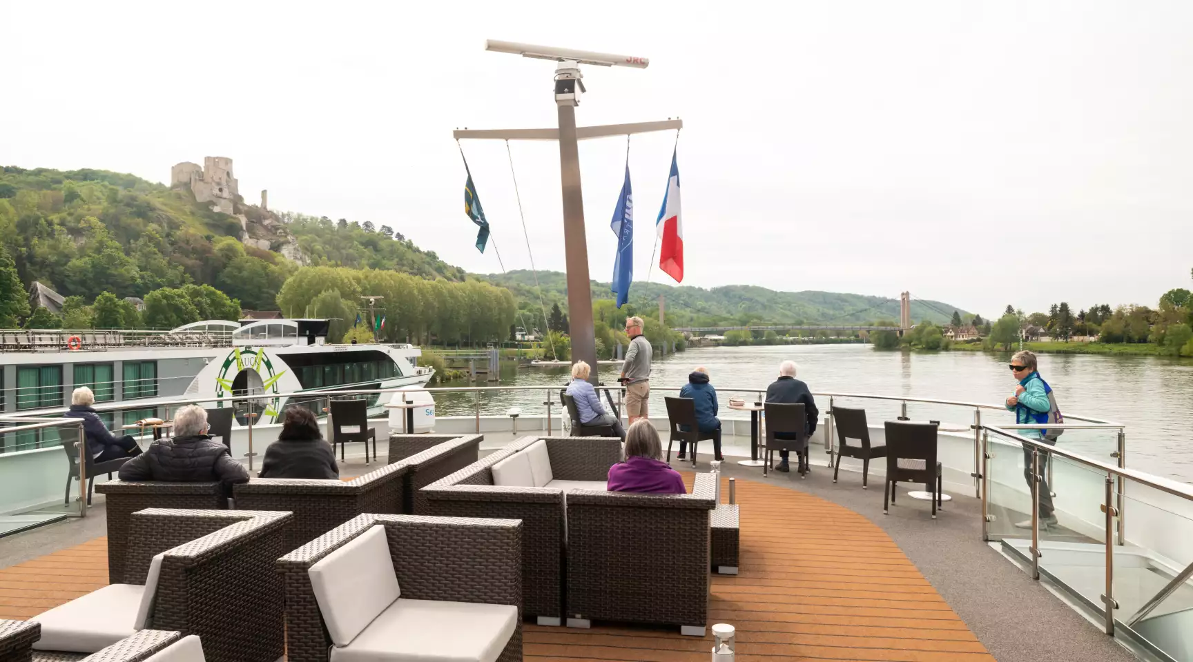 The sun deck of a river cruise ship on the Seine, with numerous people sightseeing