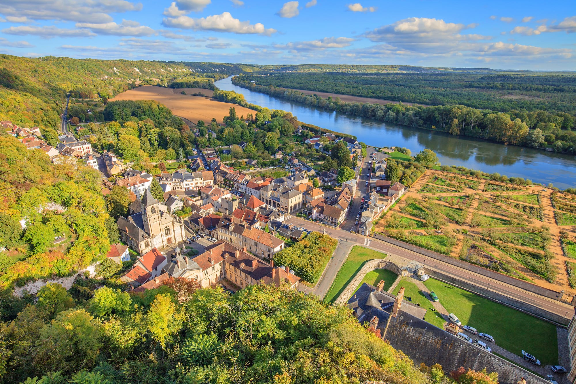 An image of La Roche-Guyon from above, with sprawling gardens to the right and the River Seine above
