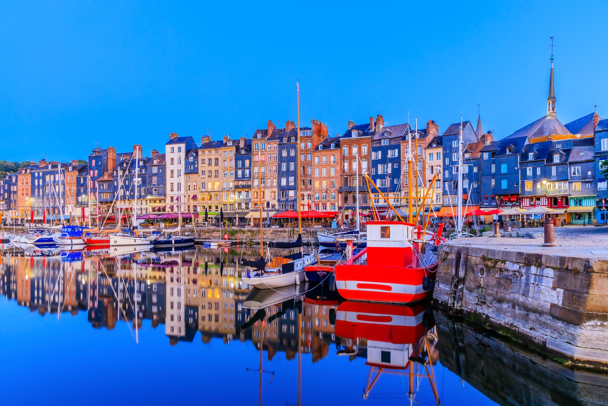 An image of Honfleur's Vieux Bassin, with colourful houses reflecting in the water