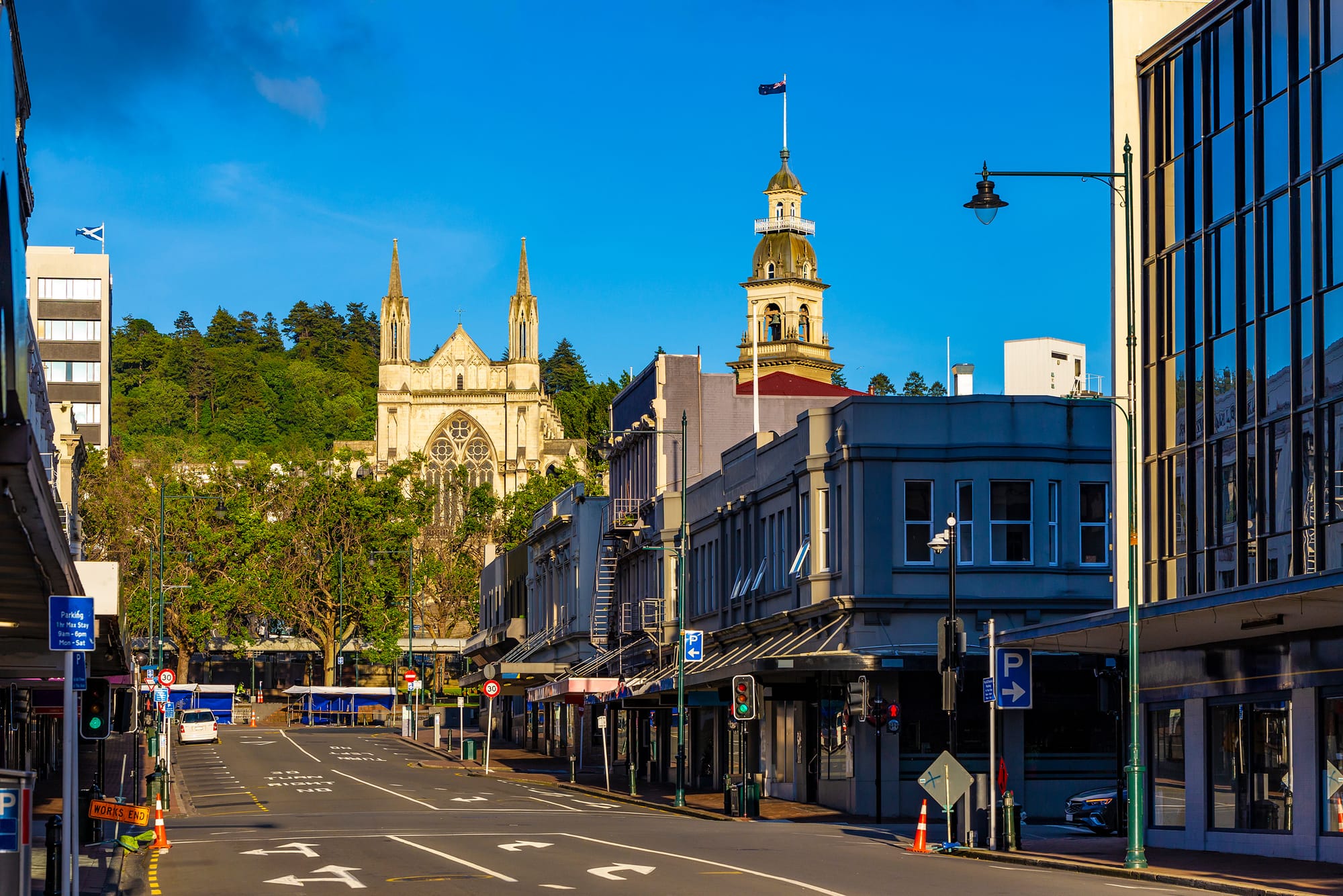 An image of a high street on a clear, sunny day in Dunedin, New Zealand, with a cathedral in the background