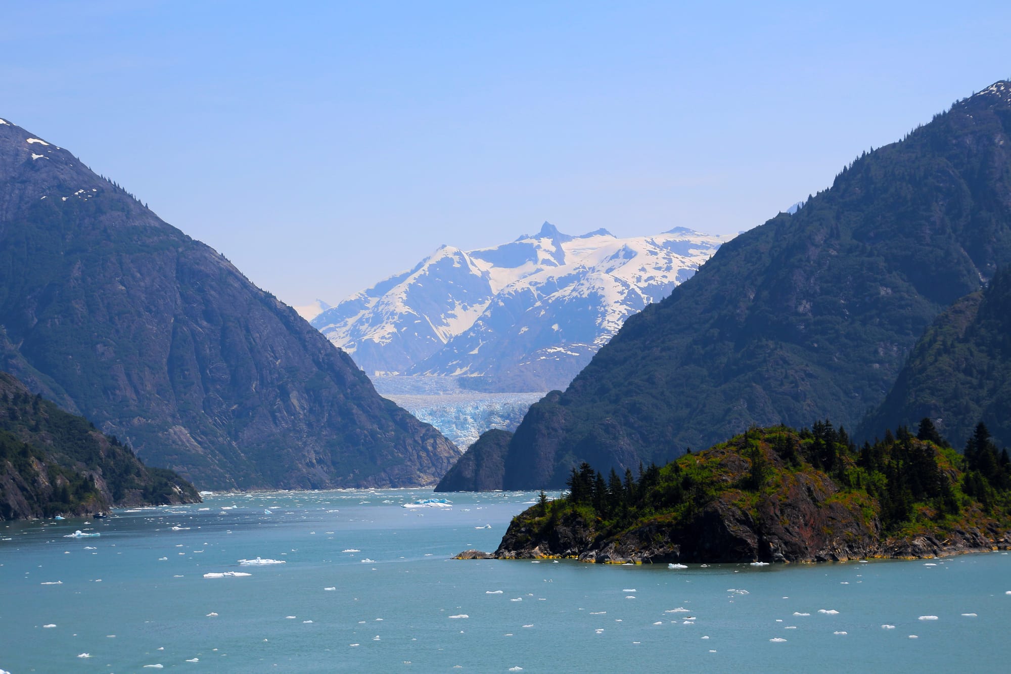 An image of a mountainous region and glacier from an Alaskan fjord with steep rocky slopes