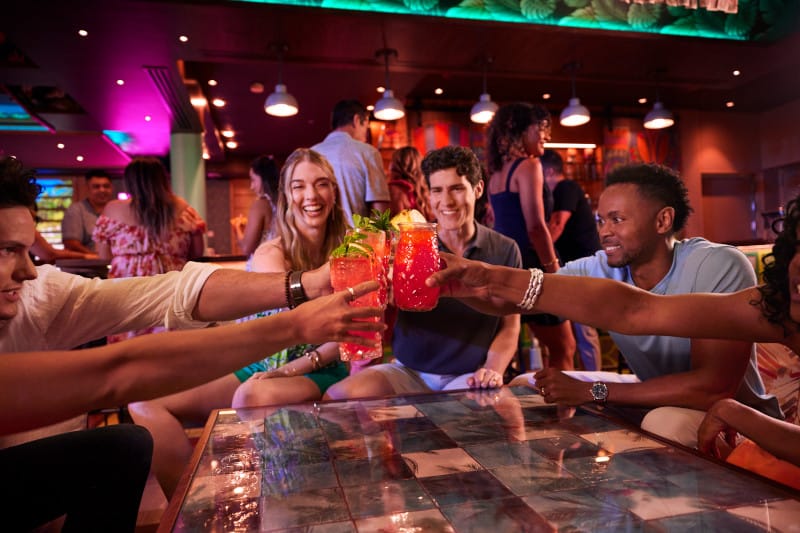 An image of a group cheersing cocktails in a bar on a Royal Caribbean cruise ship