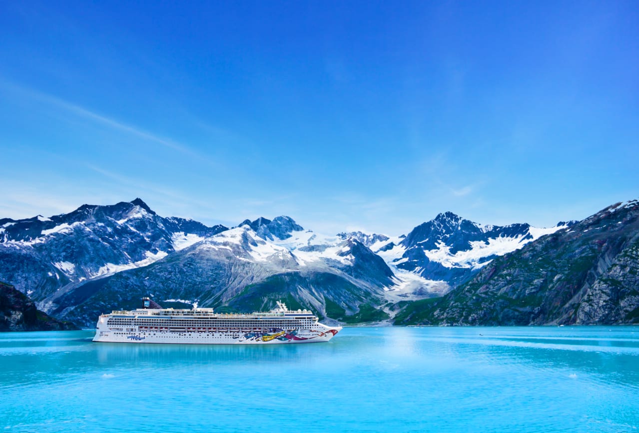 A cruise ship in Glacier Bay, with Alaskan mountains in the background
