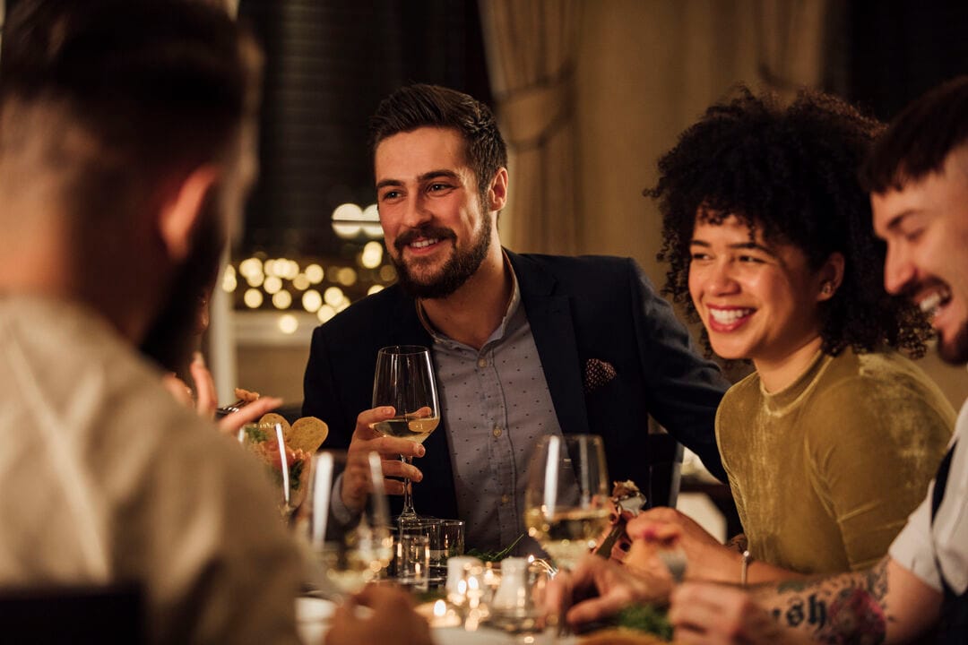 A couple enjoying a meal with wine on a cruise ship