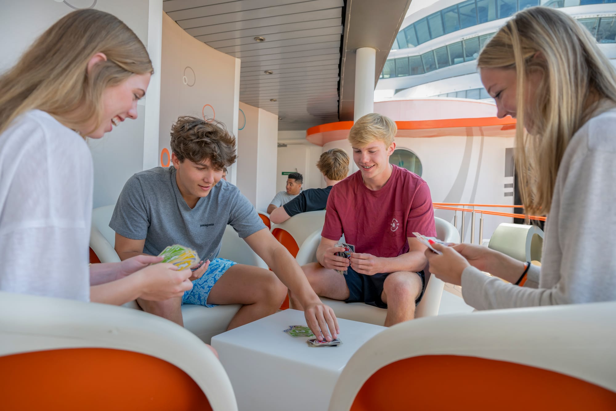 A group of teens playing a card game