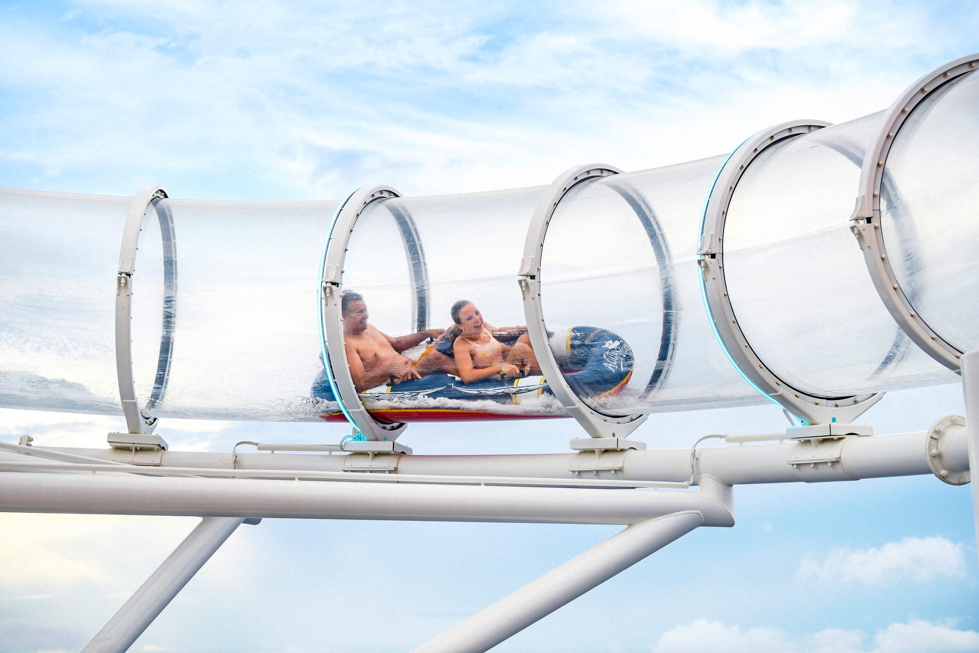 A waterslide with a raft through a clear tube