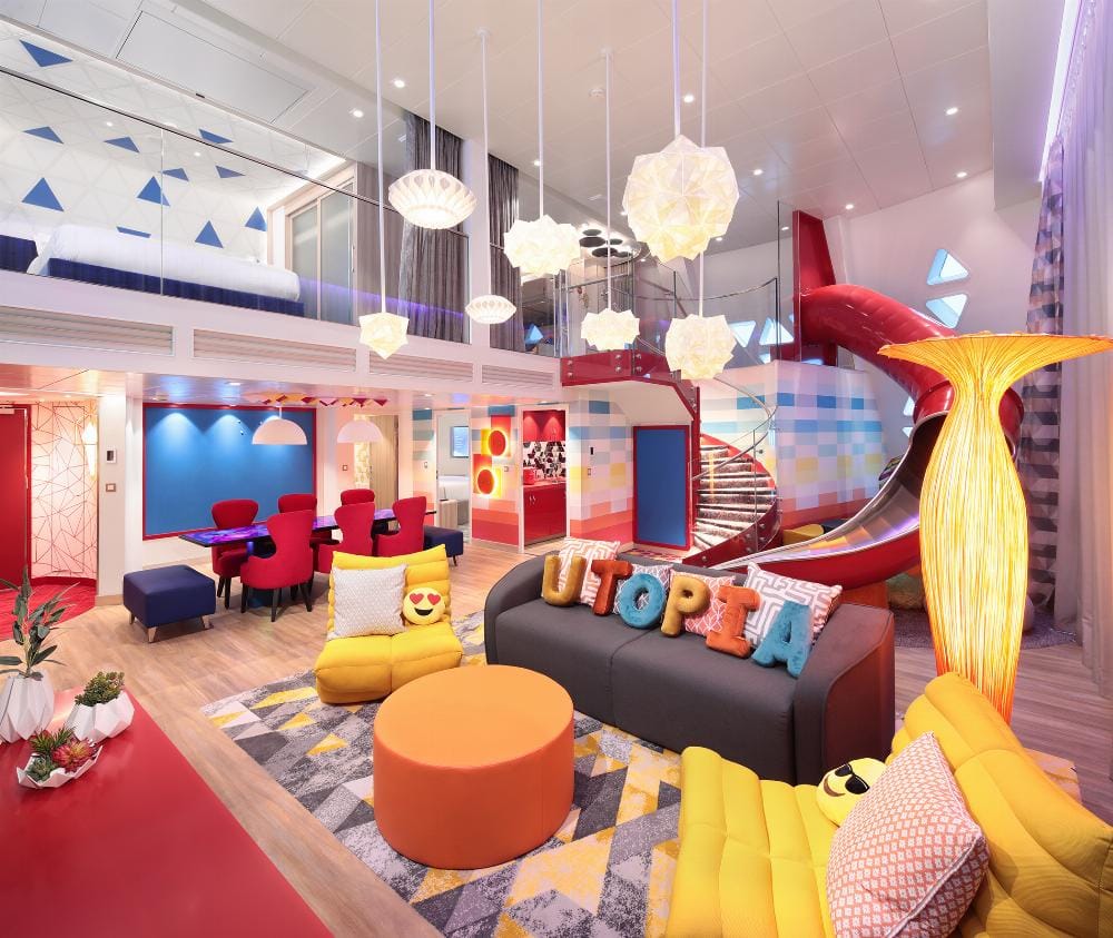 A vibrant family room with a sitting area and a slide from the second floor