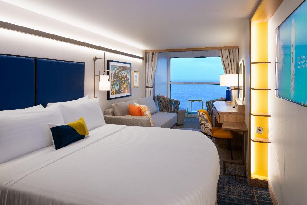 A cabin with a double bed and a French balcony window