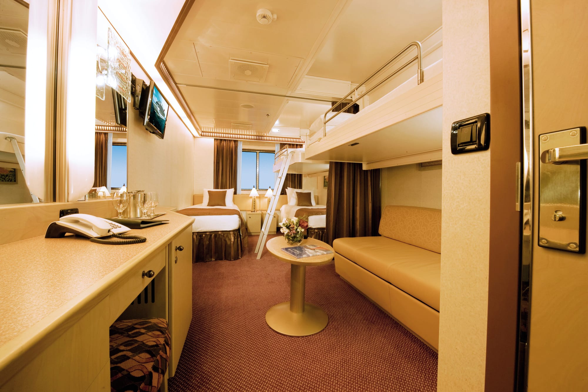 A cabin with a bunk bed above a sofa
