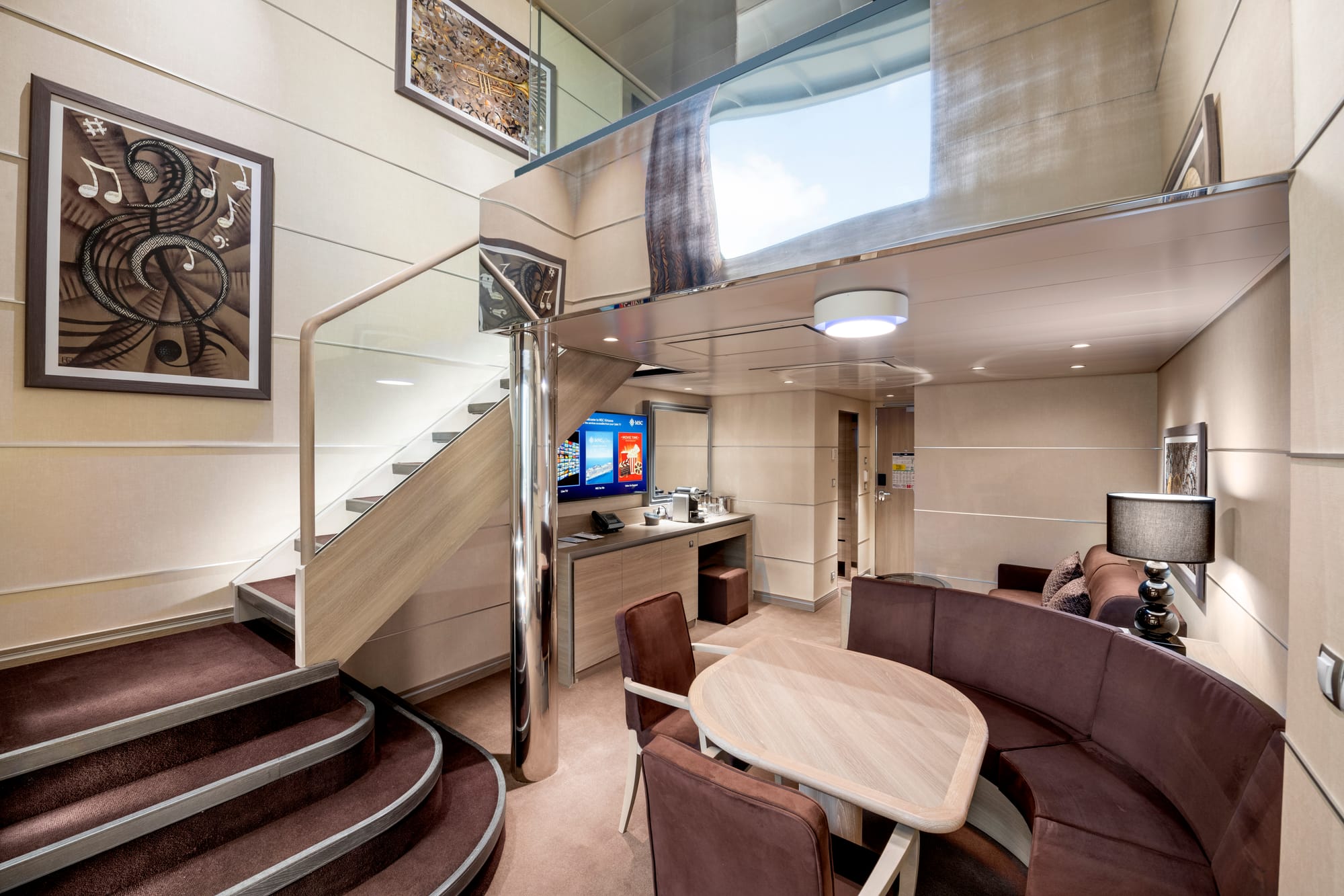 A two-story suite with a seating area and a bedroom above
