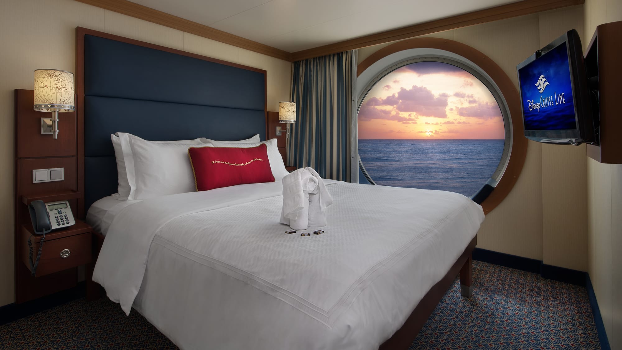 A cruise cabin with a bed and a round porthole window