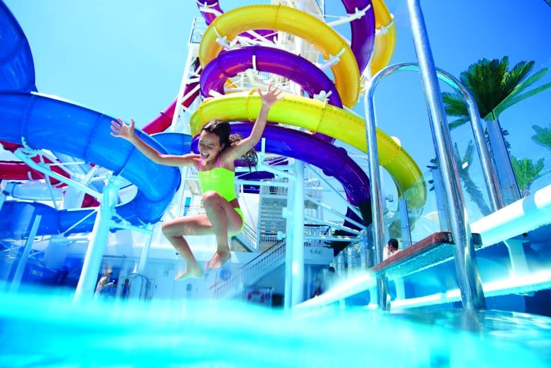 A teen jumping into a swimming pool at an Aqua Park