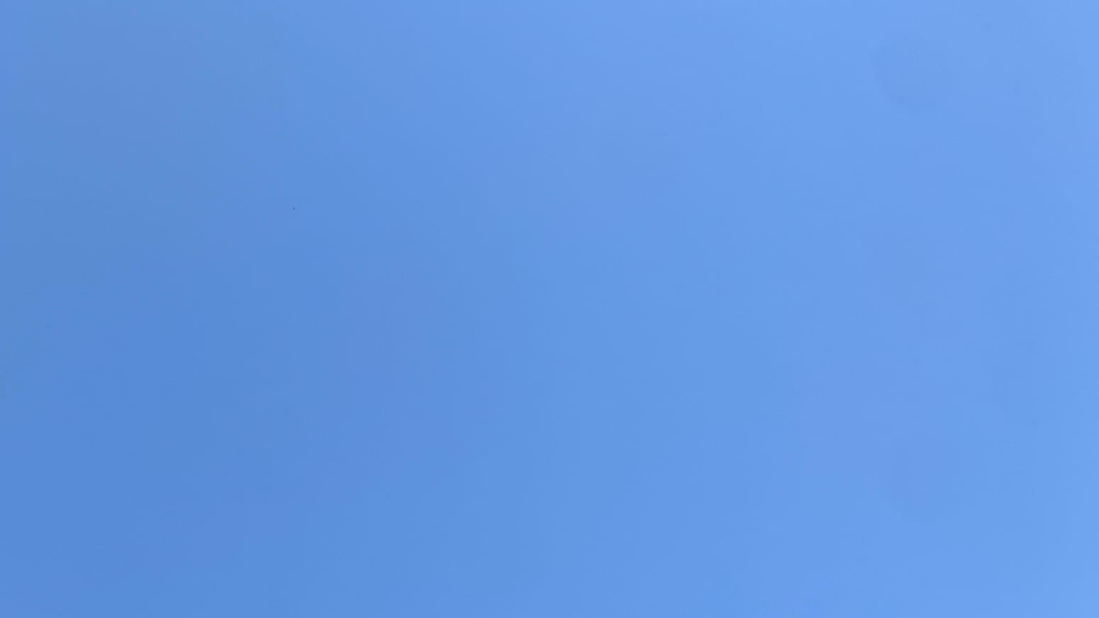 A cloudless pale blue sky, a little lighter toward the right