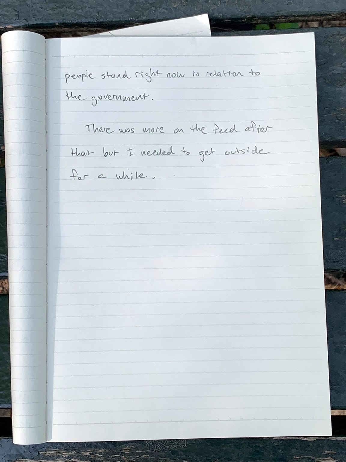 Photo of notebook page with writing in pencil:   people stand right now in relation to the government. There was more on the feed after that but I needed to get outside for a while.