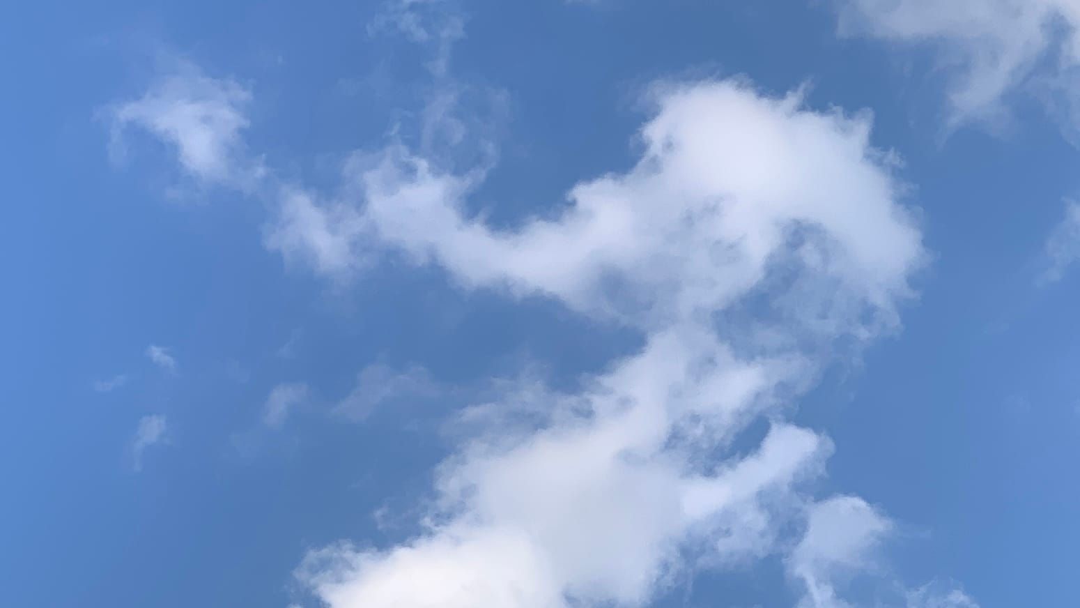 A patch of blue sky with loosely knit white clouds swooping back and forth in a sort of sideways V