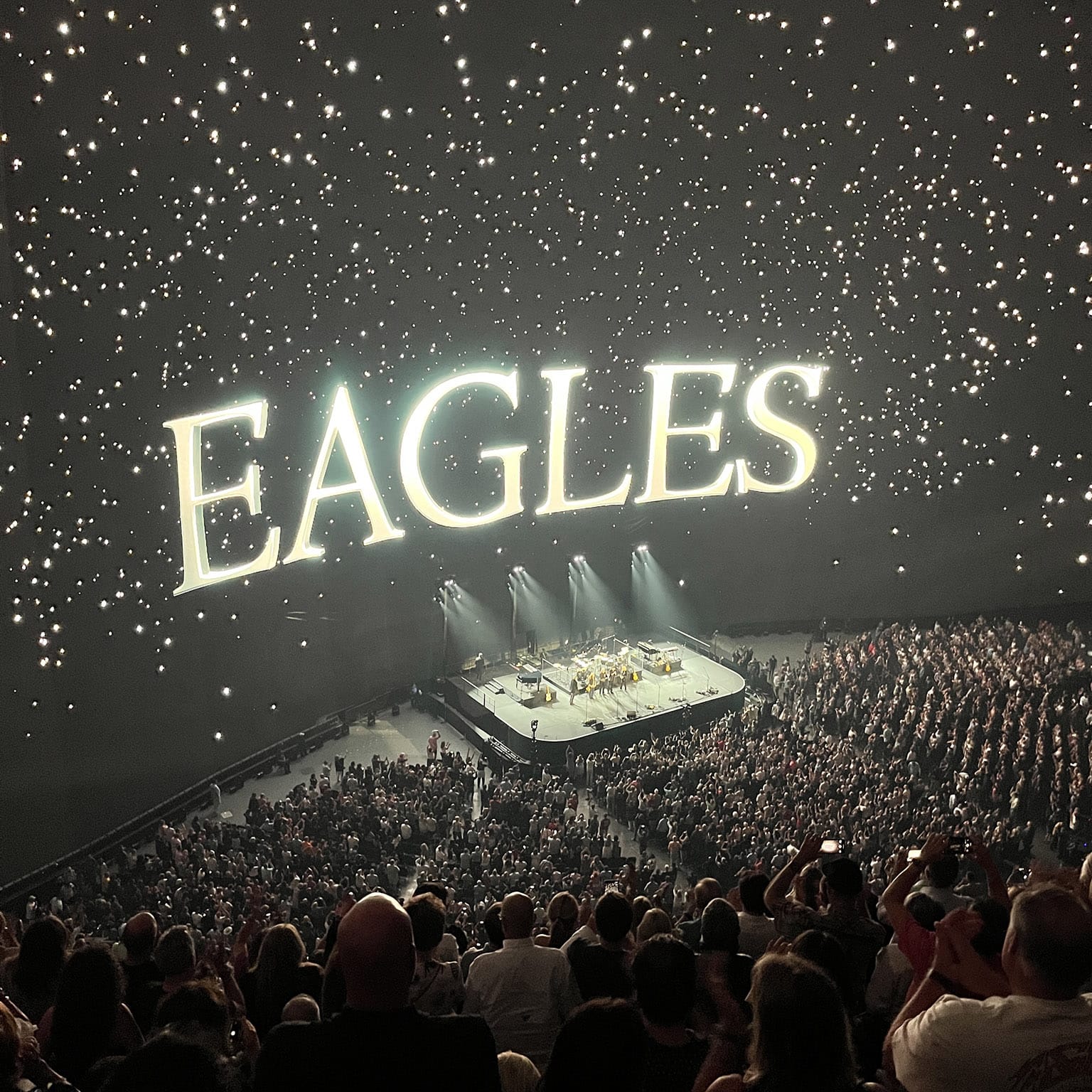 The final moment of show with big EAGLES logo projected above the band