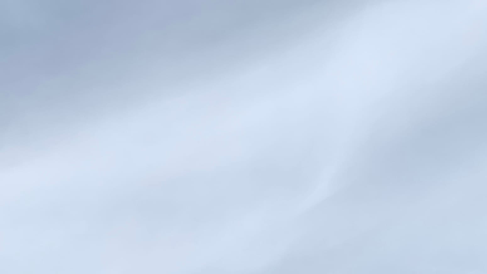 A patch of gray sky with a vaguely defined, slightly undulating area of lighter gray crossing the frame diagonally from lower left to upper right. 