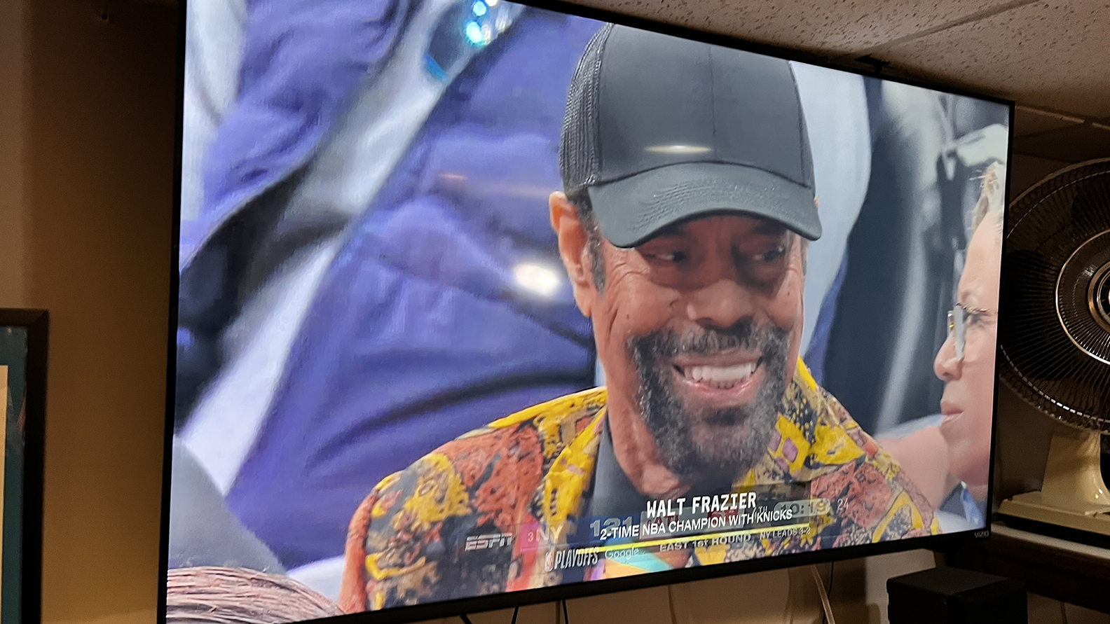 Clyde in a wildly patterned blazer. Chyron: WALT FRAZIER 2-TIME NBA CHAMPION WITH KNICKS