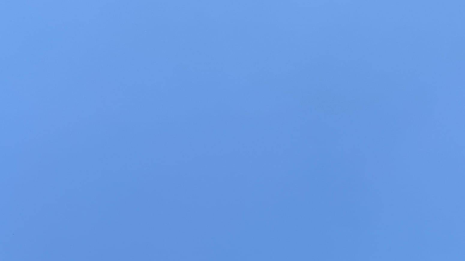 A patch of slightly haze-bleached plain blue sky. 