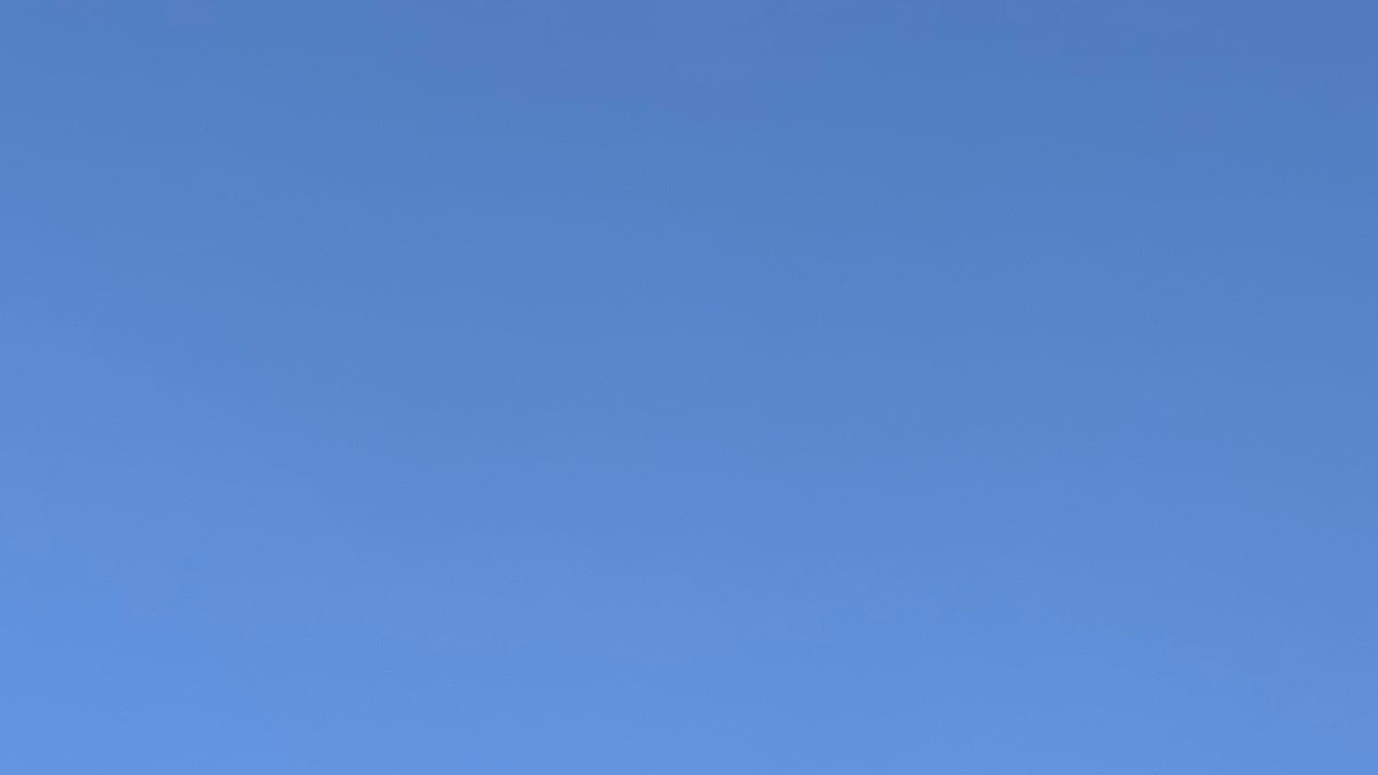 A patch of clear blue sky, a little deeper than medium blue.