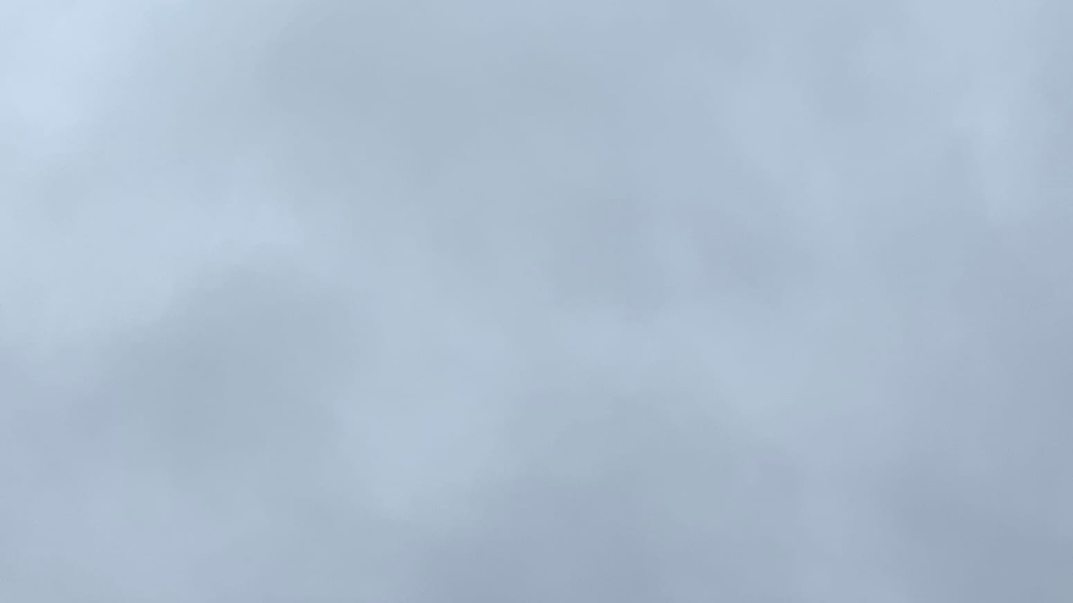 A patch of cloudy sky with indistinct variations of medium gray