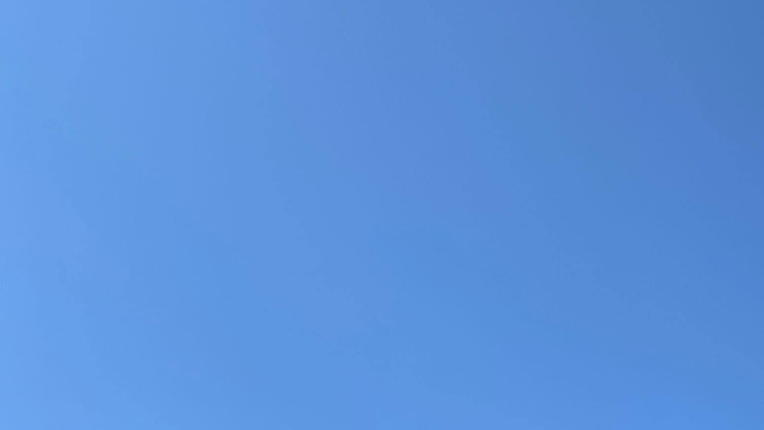 A patch of blue sky, getting slightly deeper blue from left to right. 