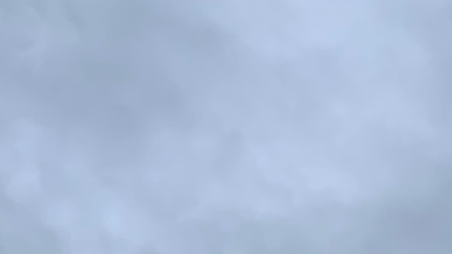 A patch of sky filled with subtly mottled gray cloud cover. 