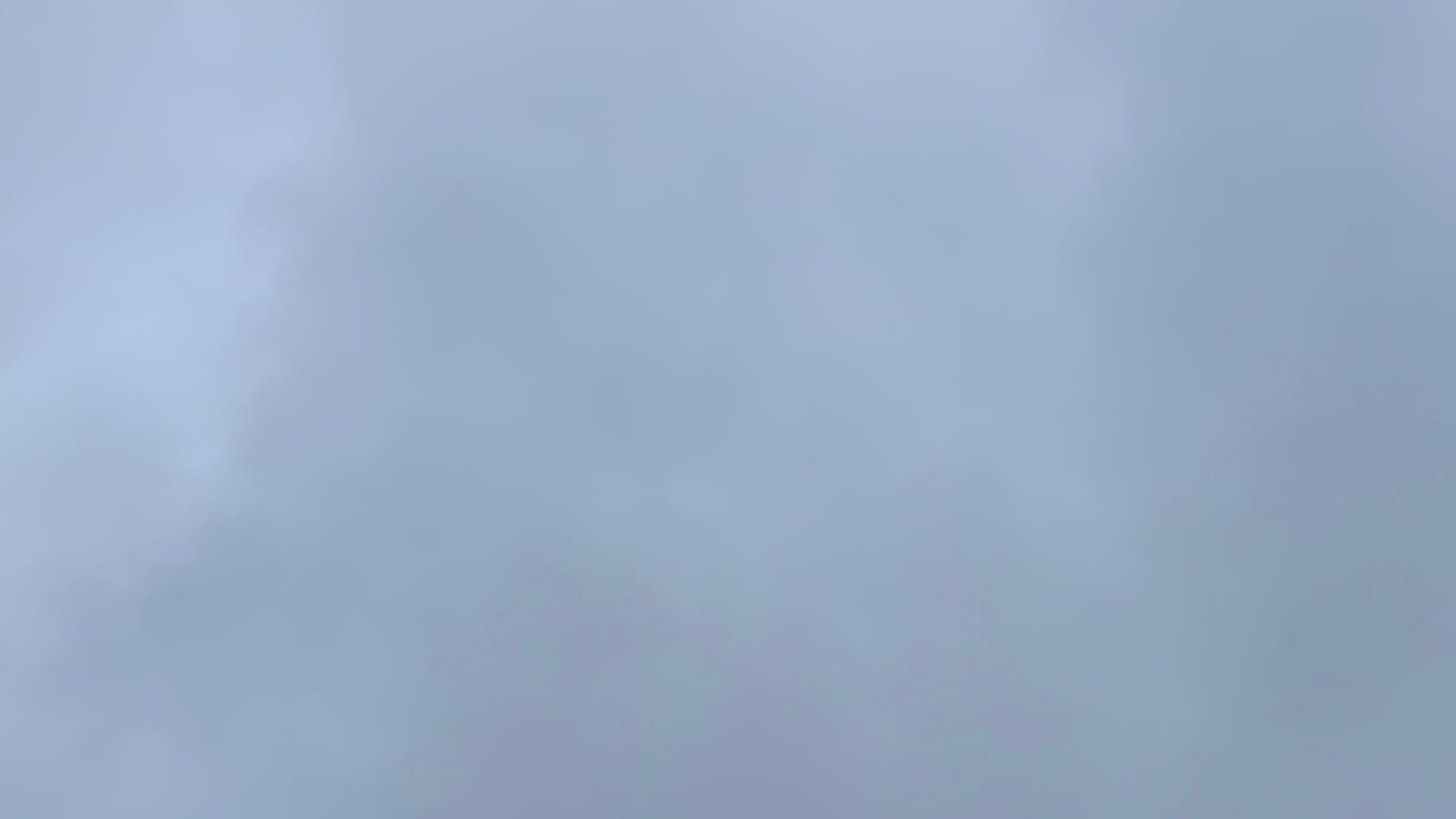 A patch of dark gray sky, slightly purple-tinged and with very faint variations in the darkness of the gray.