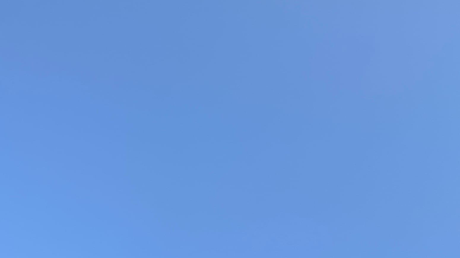 A patch of cloudless, very slightly haze-faded blue sky. 