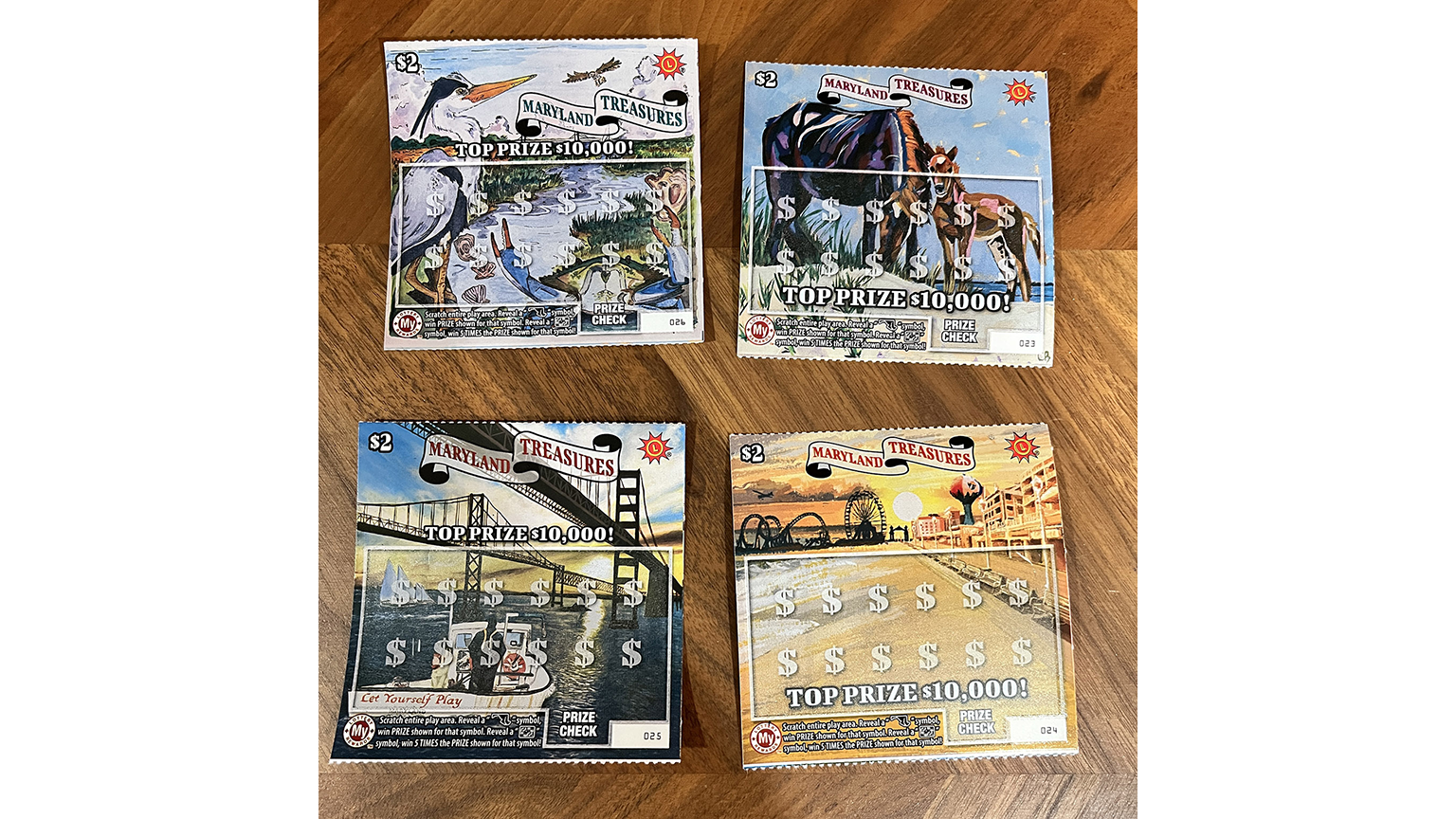Four MARYLAND TREASURES $2 scratch-offs with different Maryland scenes such as ponies as Assateague Island, a heron, the boardwalk at Ocean City, MD, and a commercial fisher piloting a small working boat
