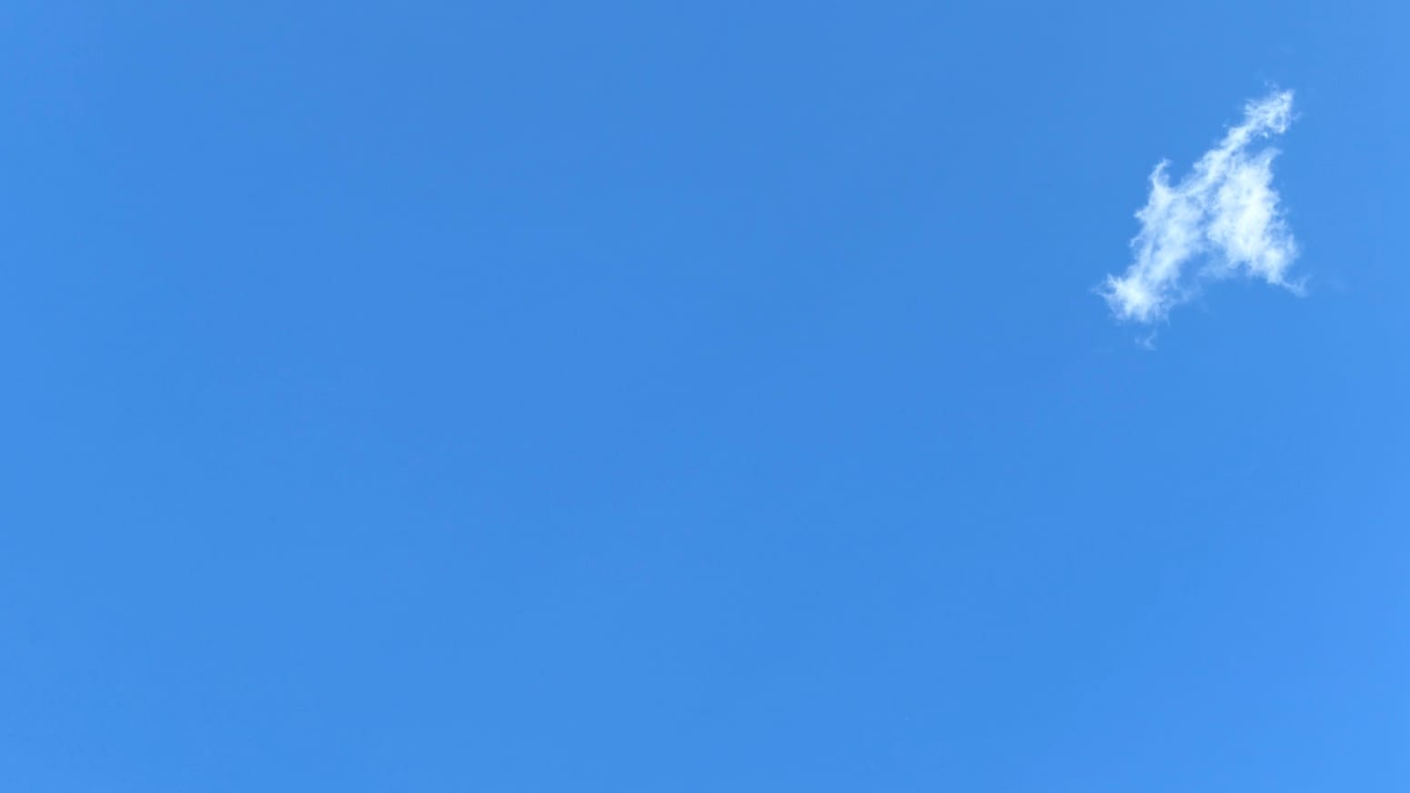 A patch of clear blue sky with a single white fractus cloud, shaped roughly like the Star Trek insignia, floating in the upper right corner, so the whole thing suggests a flag design