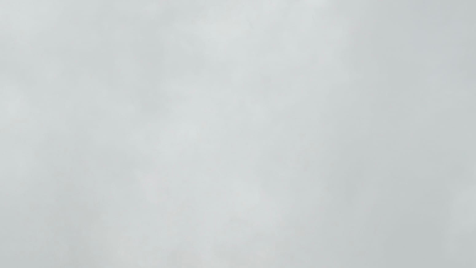 A patch of newsprint-gray sky with very faint variations in tone between different areas of the clouds.
