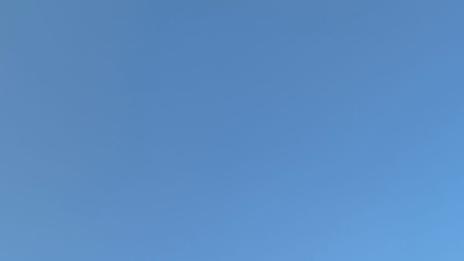 A patch of cloudless sky in a slightly dusty blue.