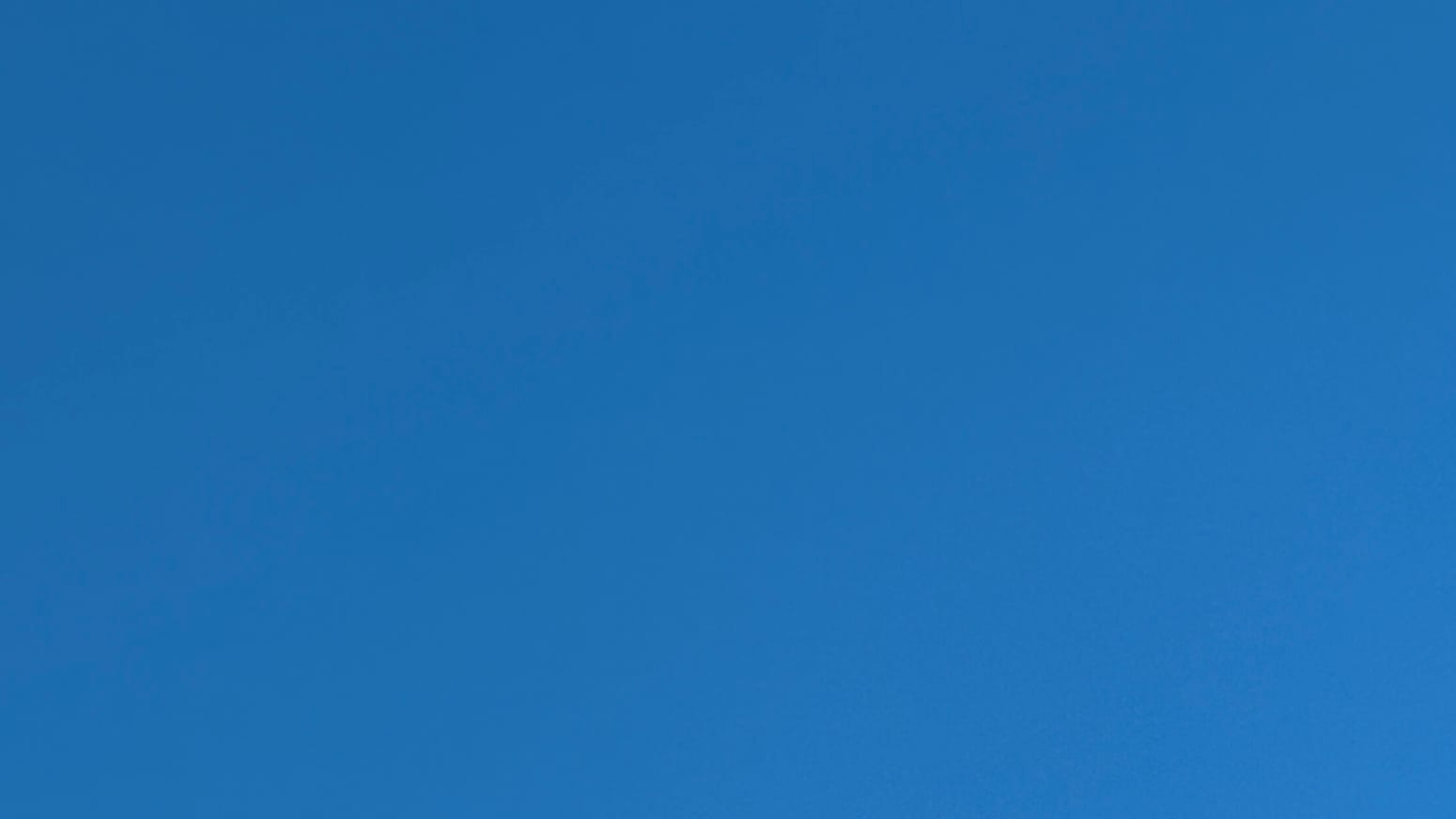 A patch of cloudless sky in a blue so deep it has a hint of oceanic green in it