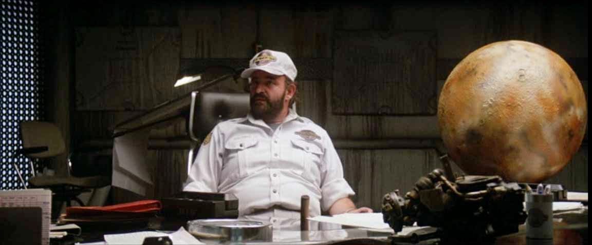Peter Boyle's character looking like a total boss (a-hole) sitting behind a desk with a model of some planet or moon or whatever next to him which also looks kind of a-hole-ish just saying