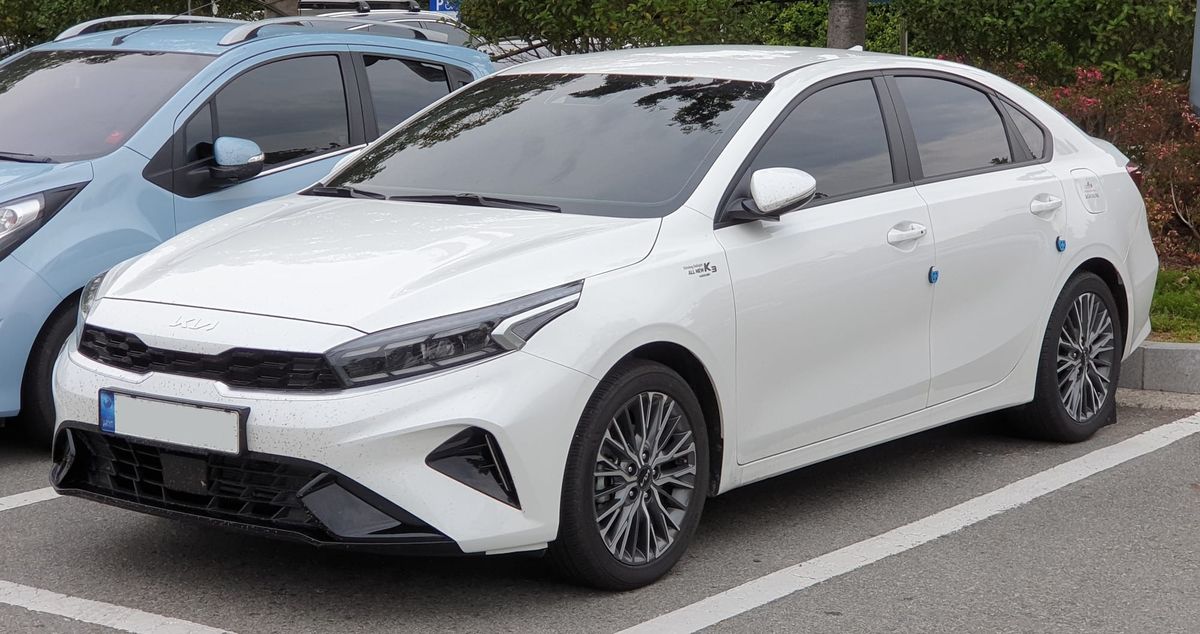 A "Kia K3 BD FL Snow White Pearl" in a parking lot