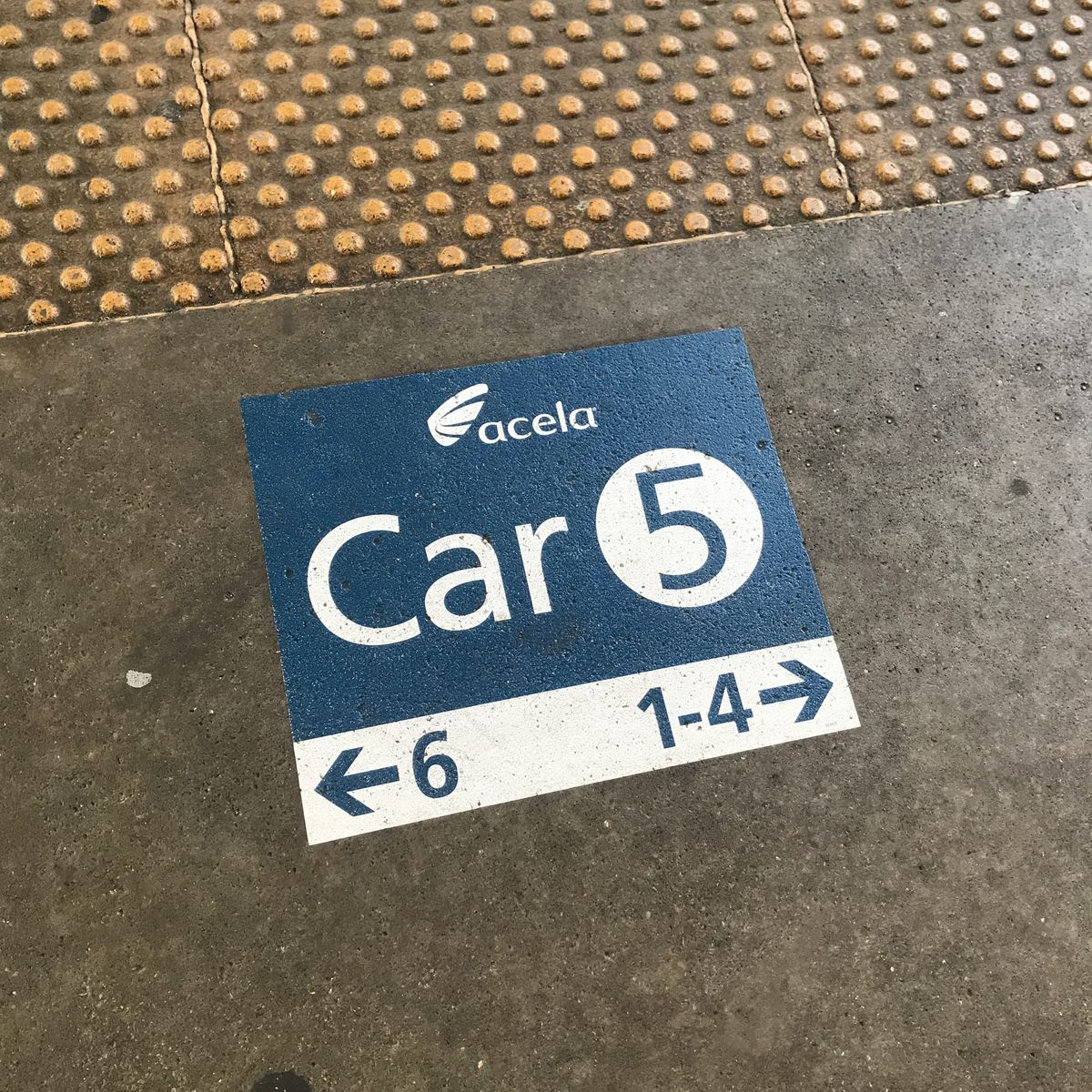 A wayfinding sticker on the floor of the train platform for ACELA CAR 5