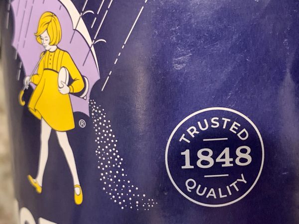 MORTON SALT LABEL girl in yellow dress under umbrella spilling salt in "TRUSTED 1848 QUALITY"