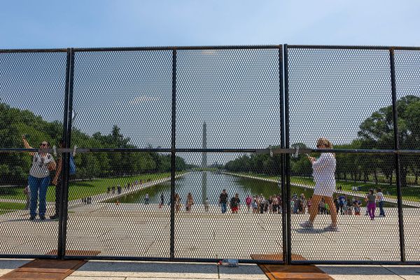 A tight-mesh fence obscuring the view of the Mall and the Washington Monument