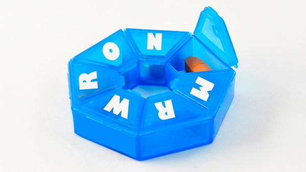 A pill case for days of the week except there's only one pill i it and the letters on the case spell M-R-W-R-O-N-G