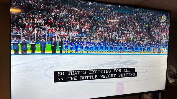 A WHOLE BUNCH OF HOCKEY PLAYERS FROM TEAM USA LINED UP FOR A MEDAL