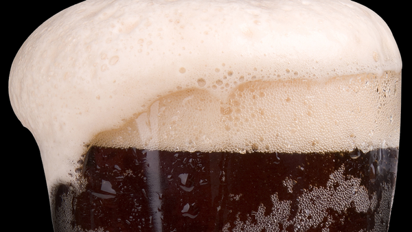 A glass of rootbeer overflowing