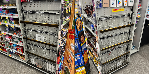 Two shots of empty magazine racks at the checkout