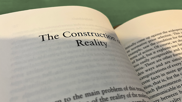 Photo of pages of the "Atlas of Realities" visible text: "The Construction of Reality... normative prior selection... 