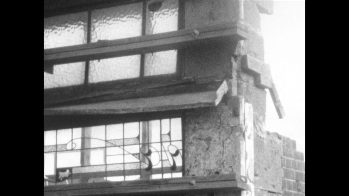 Still image of a ruined building from a black and white super 8mm film.